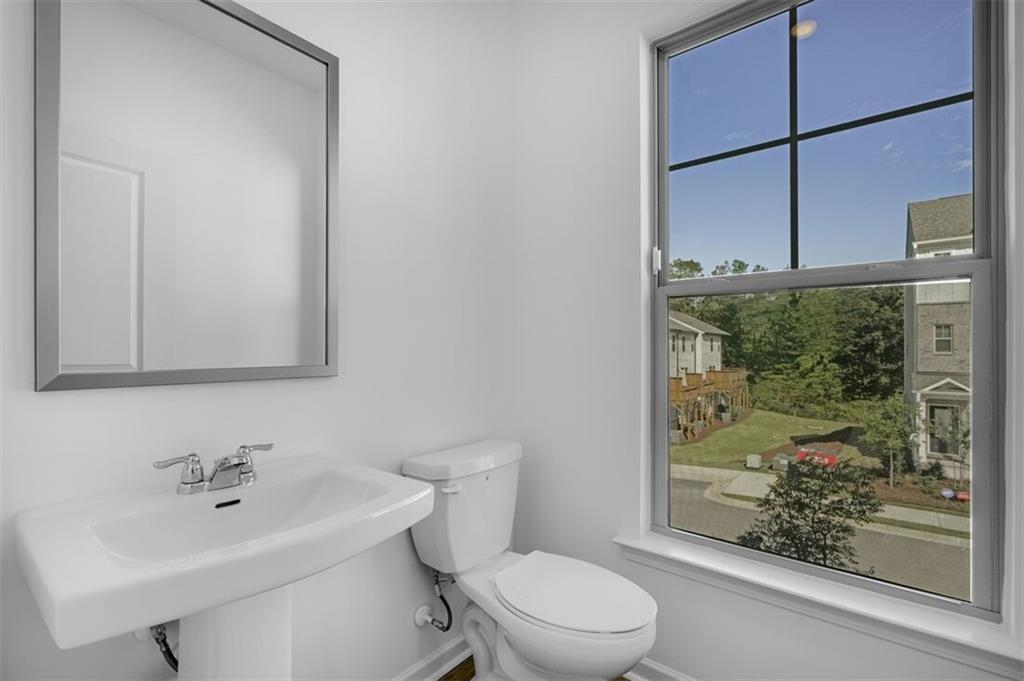 1701 Lansmere Street Southwest Marietta, GA 30008 - Photo 8 of 29 a bathroom with a toilet a sink and a mirror