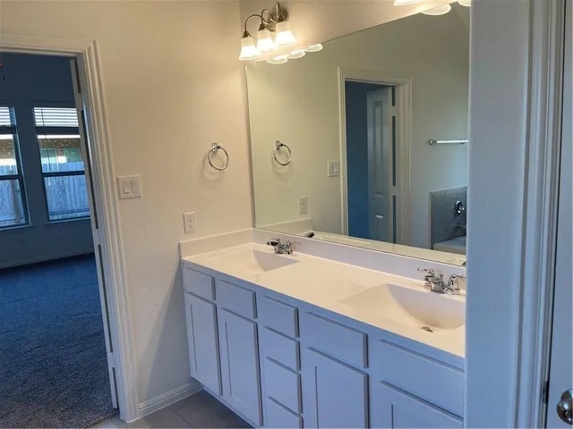 a bathroom with a tub a sink and mirror