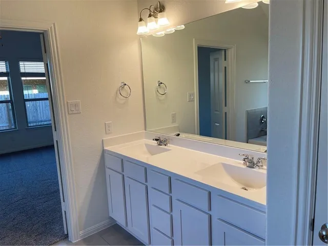 a bathroom with a tub a sink and mirror