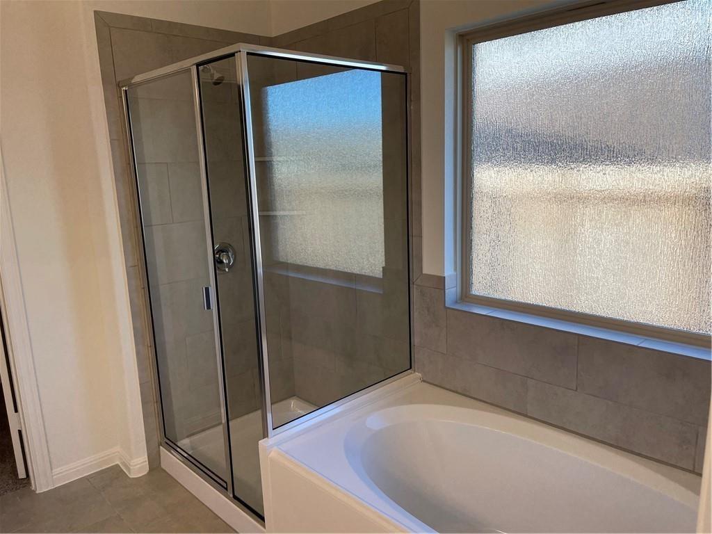 208 Baralo Street Leander, TX 78641 - Photo 12 of 23 a bathroom with a shower and a glass door