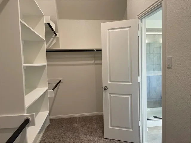 a view of walk in closet with empty racks