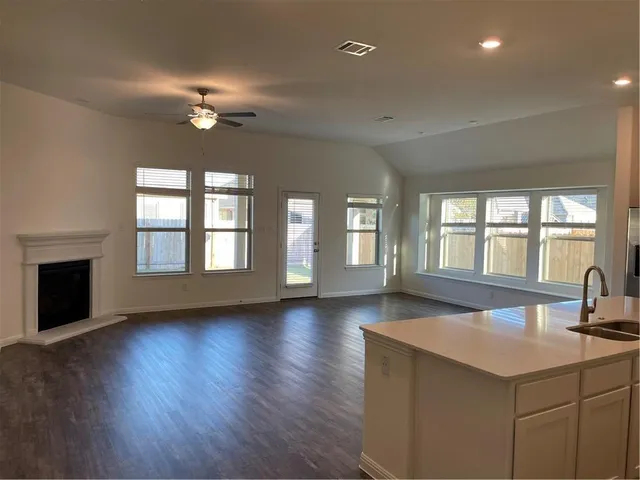 an empty room with wooden floor and chandelier