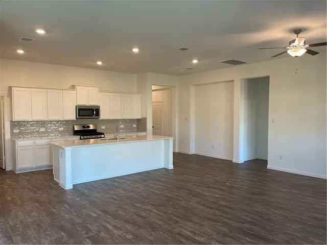 a view of kitchen with granite countertop cabinets and refrigerator