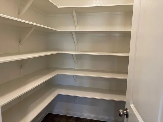 a view of walk in closet with empty racks