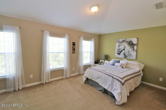 12935 Spring Rain Road Jacksonville, FL 32258 - Photo 11 of 28 a bed sitting in a spacious bedroom next to a window