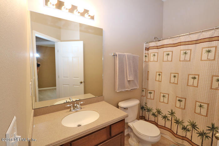12935 Spring Rain Road Jacksonville, FL 32258 - Photo 17 of 28 a bathroom with a granite countertop sink toilet a mirror a bathtub and shower