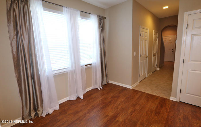 12935 Spring Rain Road Jacksonville, FL 32258 - Photo 9 of 28 an empty room with wooden floor and a window