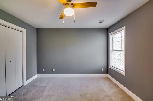 an empty room with windows and closet