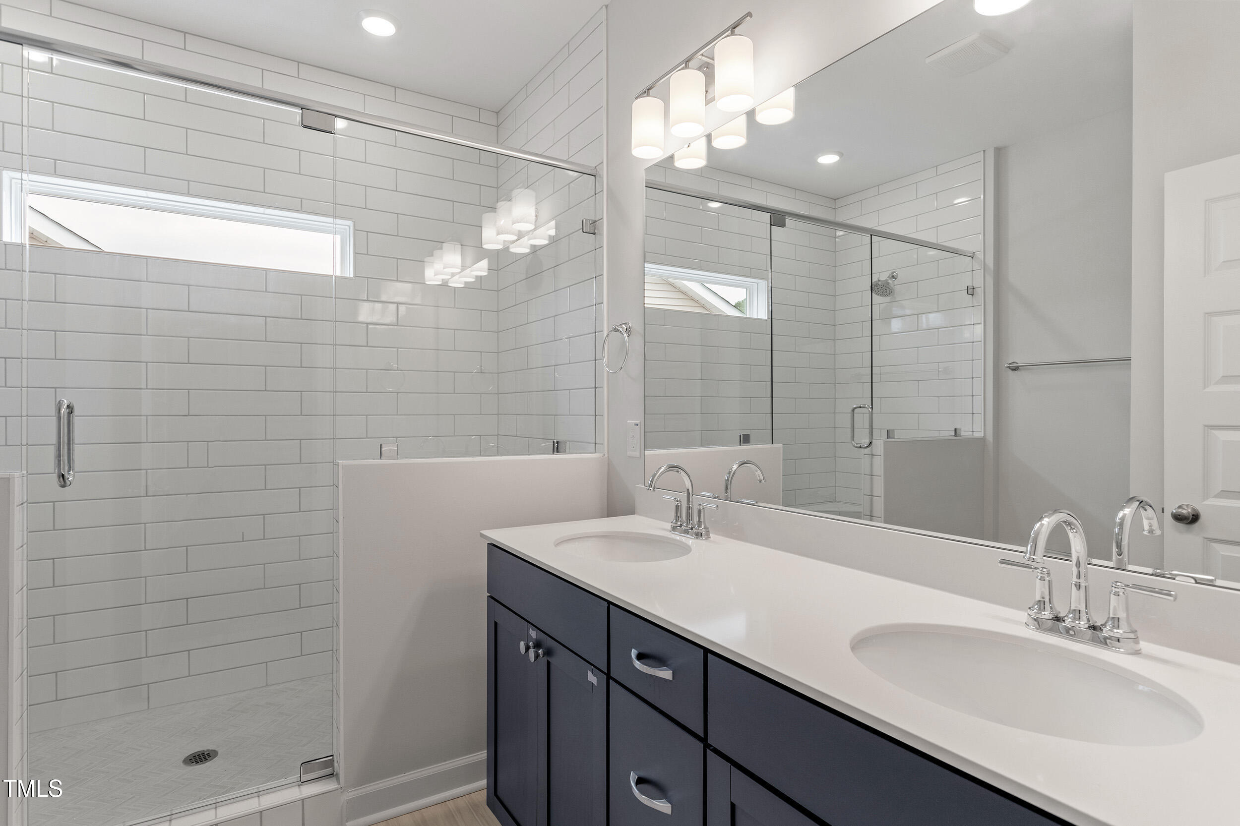 239 Meadowbark Bend, Unit 27 Garner, NC 27529 - Photo 17 of 36 a bathroom with a shower sink and mirror