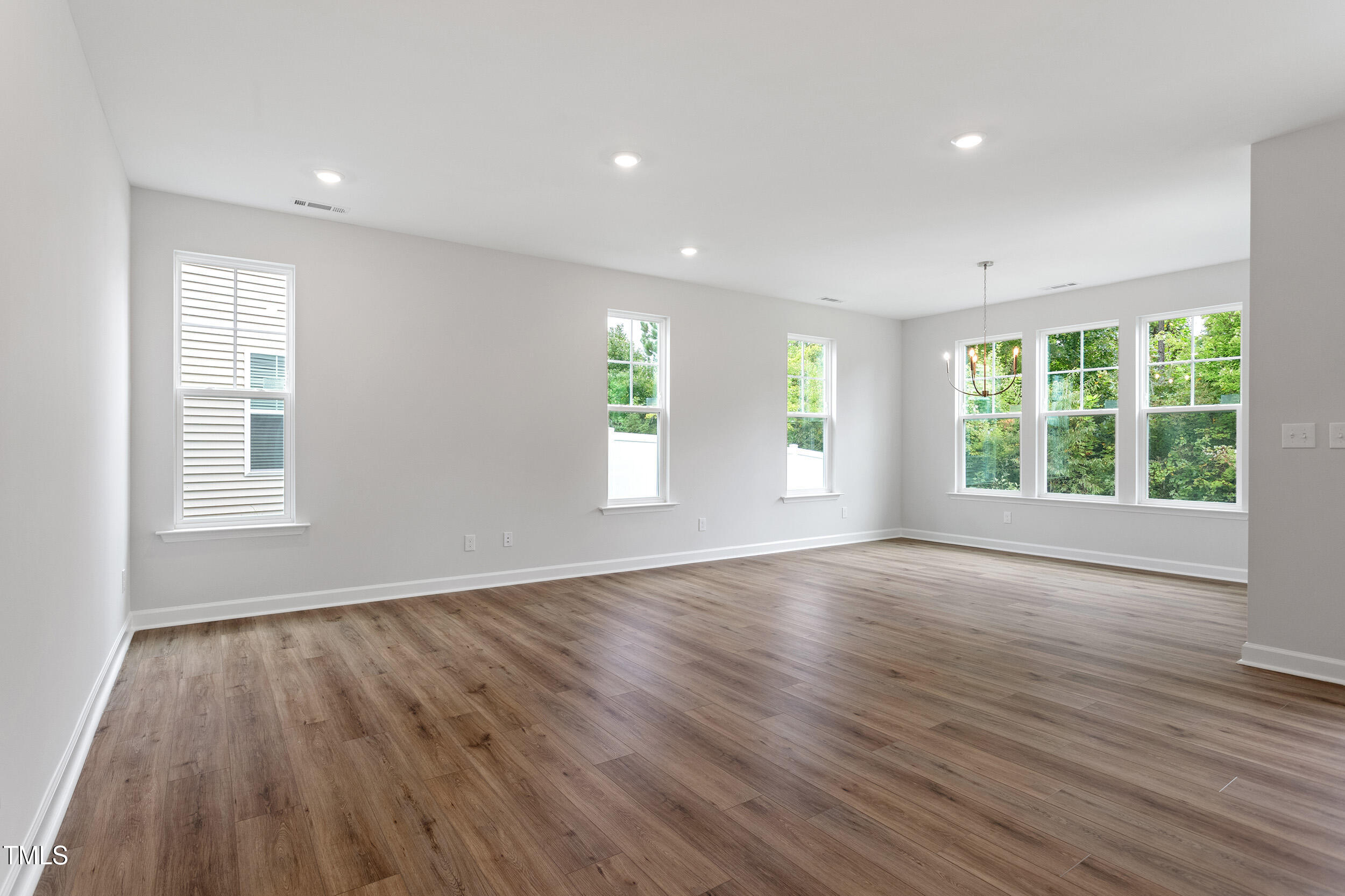 239 Meadowbark Bend, Unit 27 Garner, NC 27529 - Photo 5 of 36 a view of an empty room with wooden floor and a window
