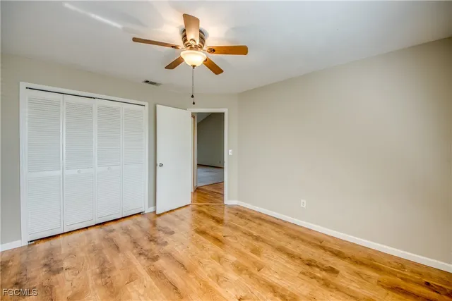 an empty room with a ceiling fan and carpet