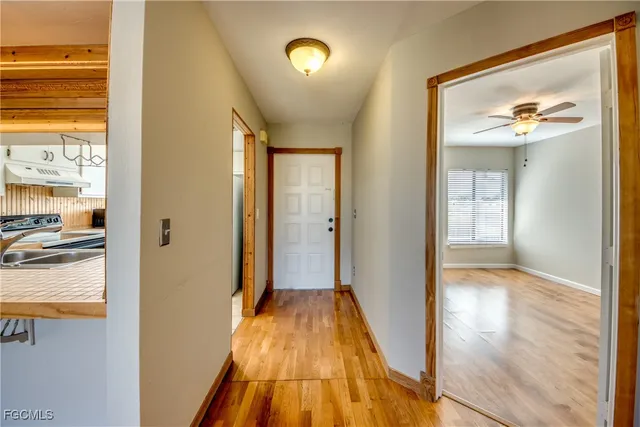 a view of a hallway with wooden floor and a living room