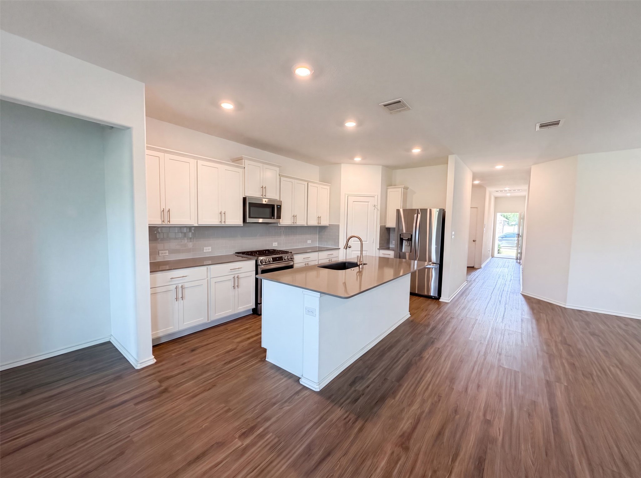 424 Wolf Springs Road Georgetown, TX 78628 - Photo 2 of 15 A well-appointed kitchen features a large island and contemporary stainless steel appliances, seamlessly connecting to an open living area.