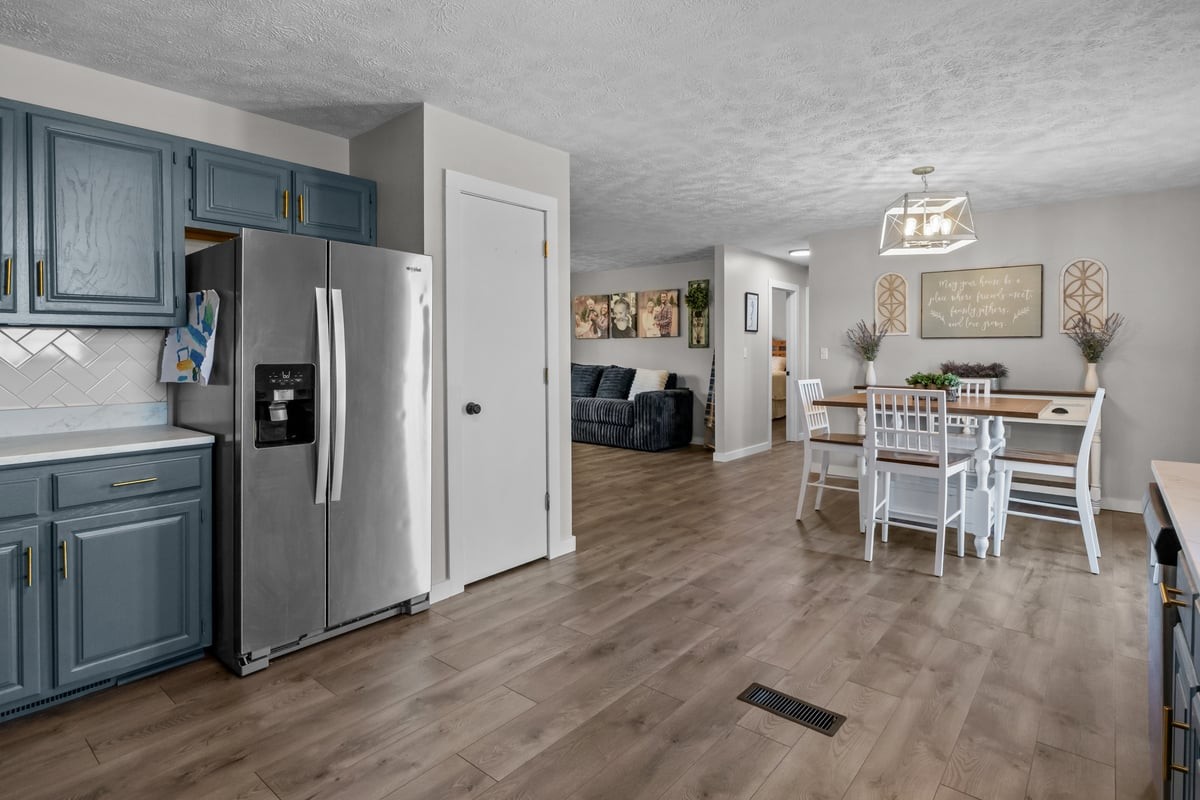 365 Little Benton Road Mansfield, TN 38236 - Photo 16 of 53 a kitchen with stainless steel appliances a refrigerator a stove a dining table and chairs with wooden floor