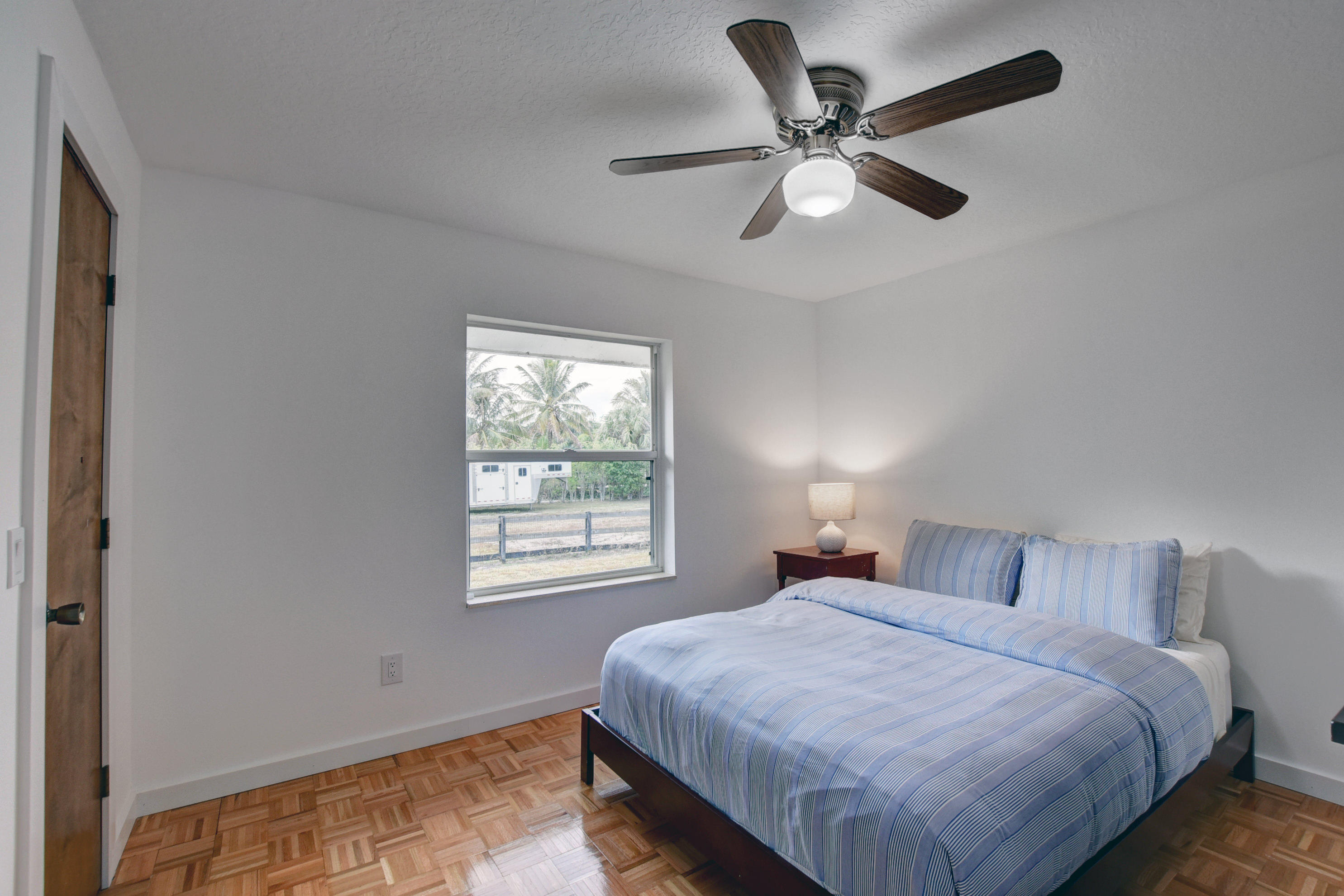 16493 Rustic Road Wellington, FL 33470 - Photo 21 of 57 a bedroom with a large bed and a large window