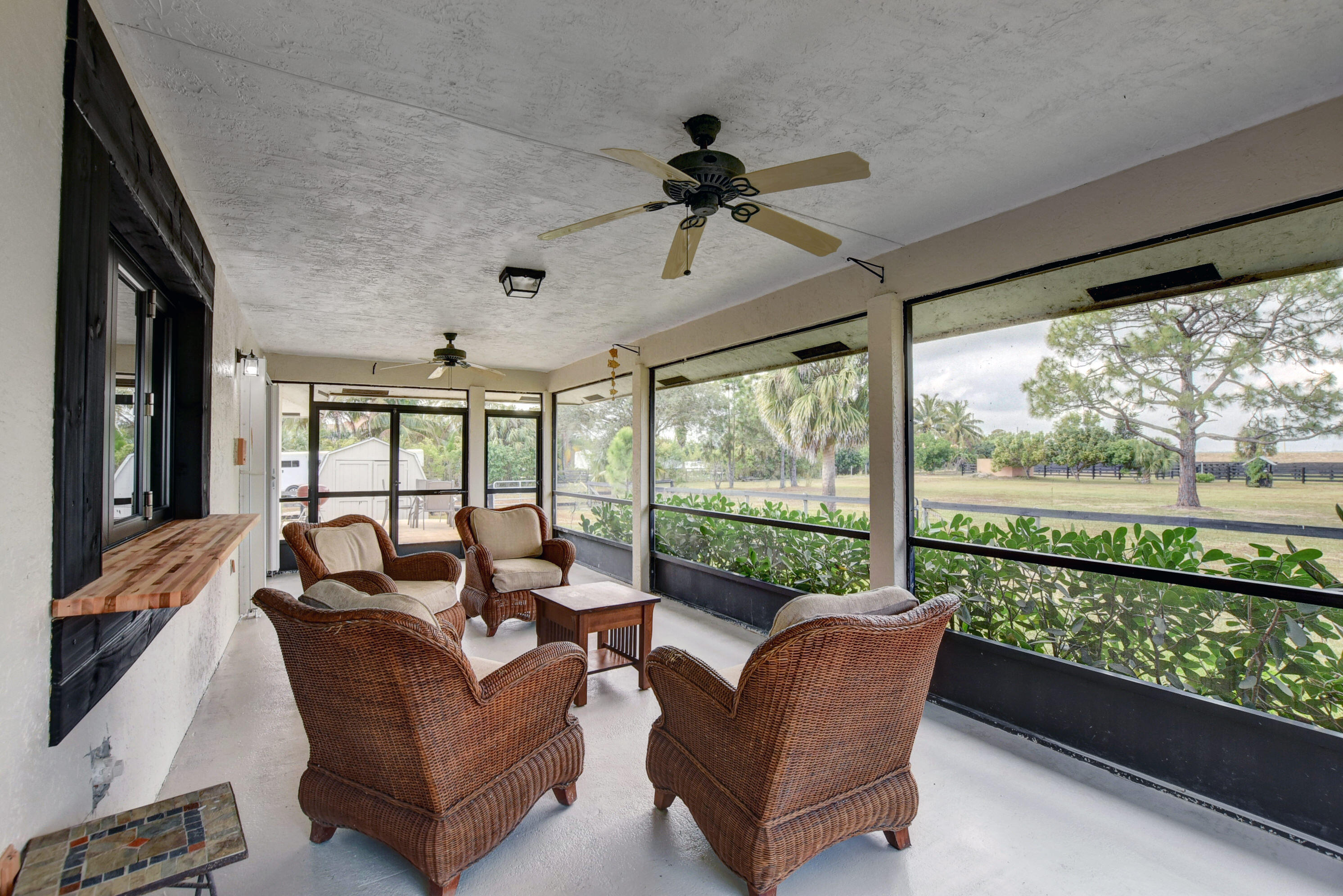 16493 Rustic Road Wellington, FL 33470 - Photo 26 of 57 a living room with furniture and a floor to ceiling window