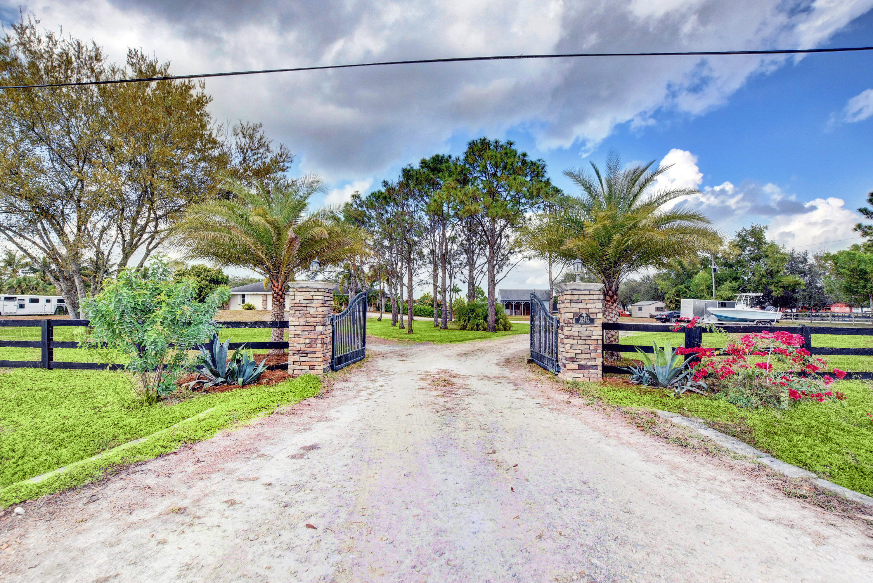 16493 Rustic Road Wellington, FL 33470 - Photo 40 of 57 a view of a park with potted plants and palm trees