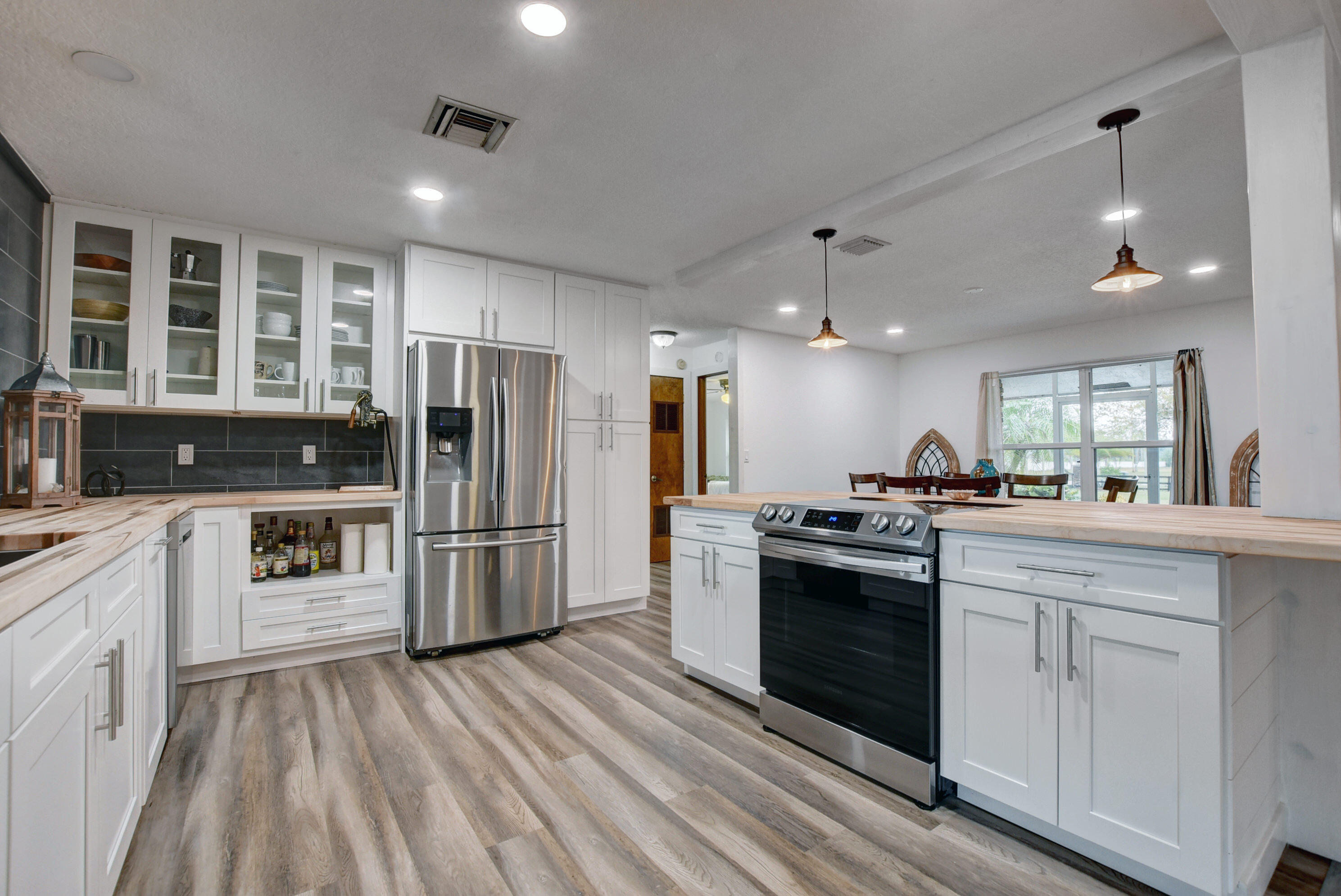 16493 Rustic Road Wellington, FL 33470 - Photo 8 of 57 a kitchen with stainless steel appliances kitchen island granite countertop a sink stove and refrigerator
