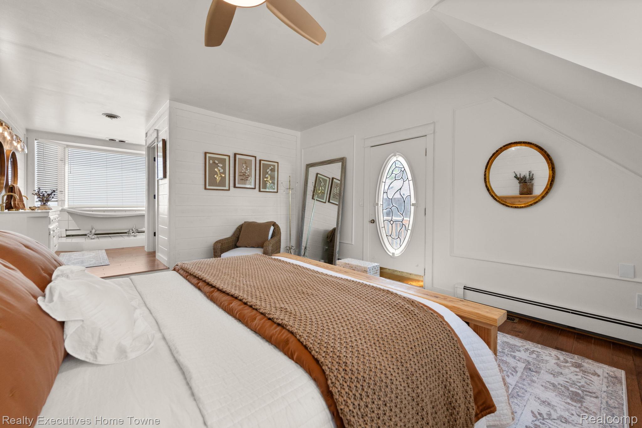 8308 Lakeshore Road Fort Gratiot, MI 48059 - Photo 65 of 79 Room featuring white shiplap wall, wood-finish flooring, ceiling fan, and a door with an oval stained-glass insert