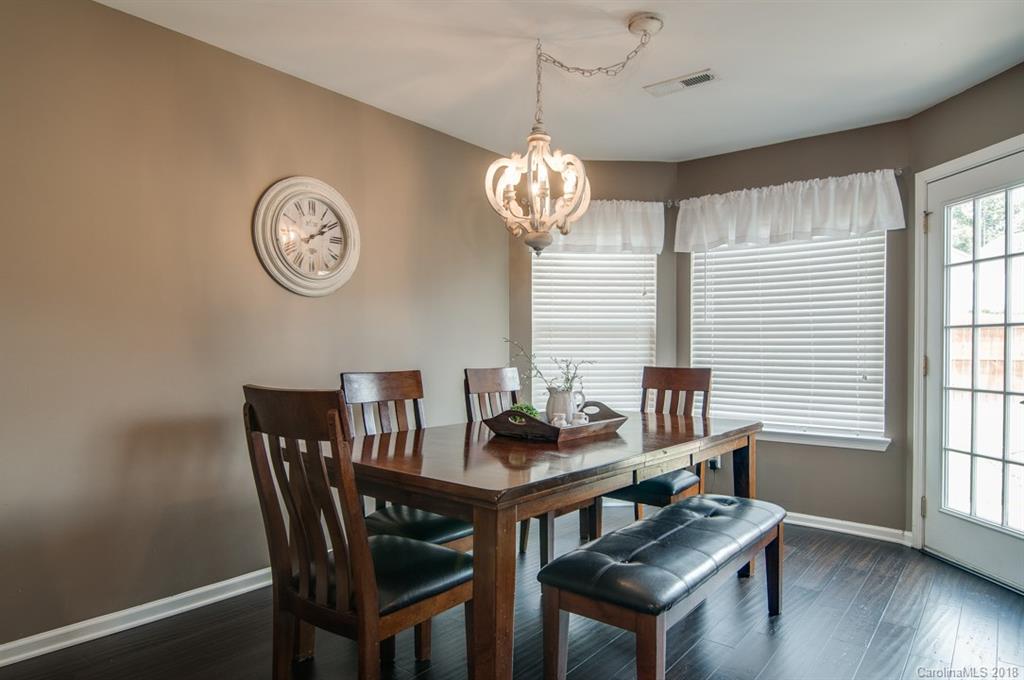 721 Jones Branch Road, Unit 75 Fort Mill, SC 29715 - Photo 13 of 36 a view of a dining room with furniture wooden floor and a chandelier