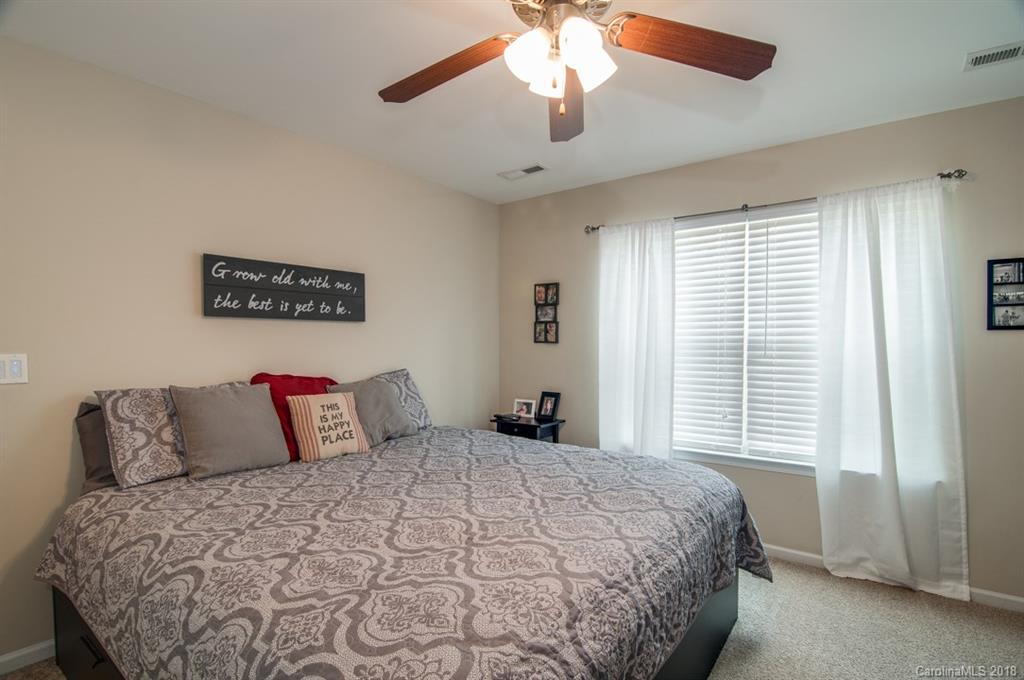 721 Jones Branch Road, Unit 75 Fort Mill, SC 29715 - Photo 22 of 36 a bedroom with a large bed and a chandelier