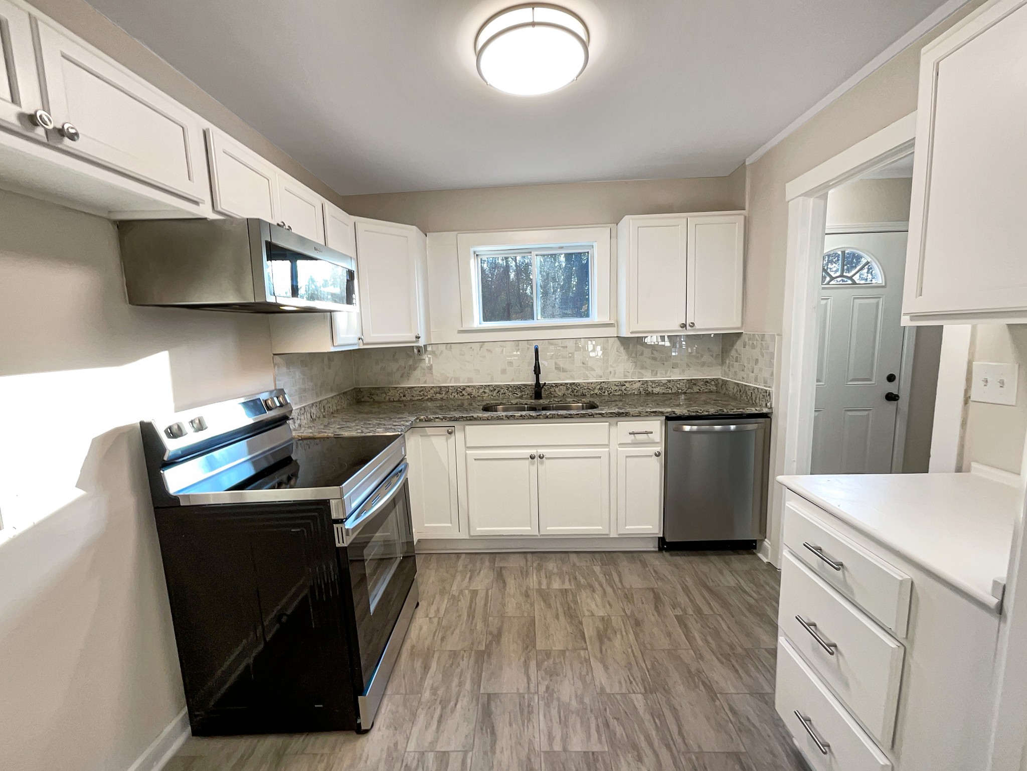 690 Thomas Road Lebanon, TN 37087 - Photo 7 of 17 a kitchen with granite countertop a sink stove and cabinets