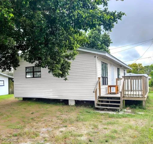 a view of a house with wooden deck and a swimming pool