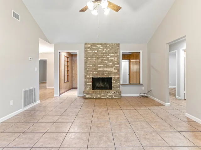 a view of an empty room with a fireplace and a window