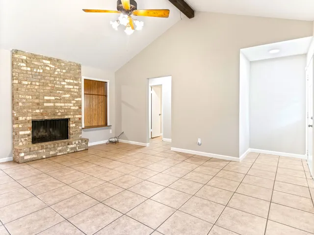 a view of an empty room with a fireplace and a window