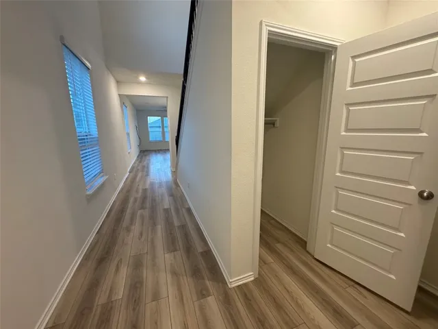 a view of a hallway with wooden floor and staircase