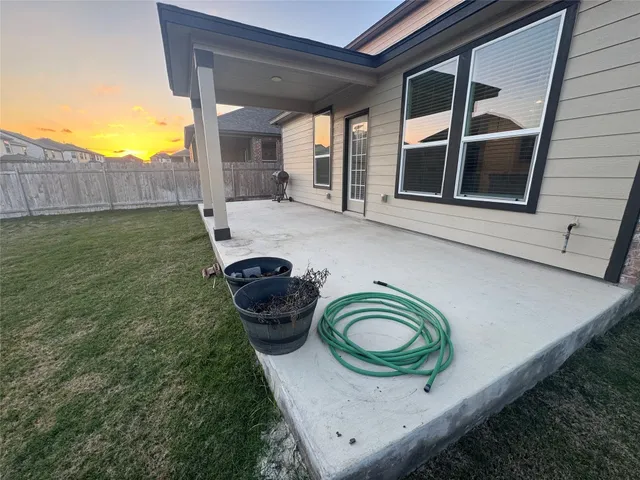 a view of backyard of house with wooden fence