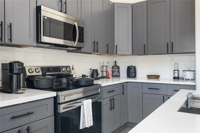 a kitchen with appliances a sink and cabinets