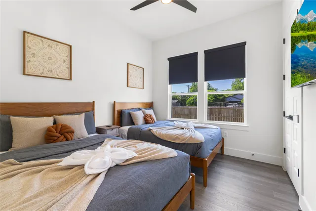 a bedroom with two beds and a large window