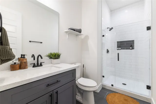 a bathroom with a sink a toilet and shower