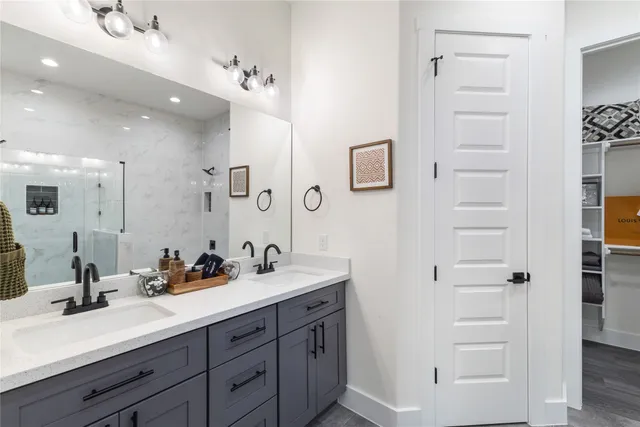 a bathroom with a double vanity sink a mirror and shower