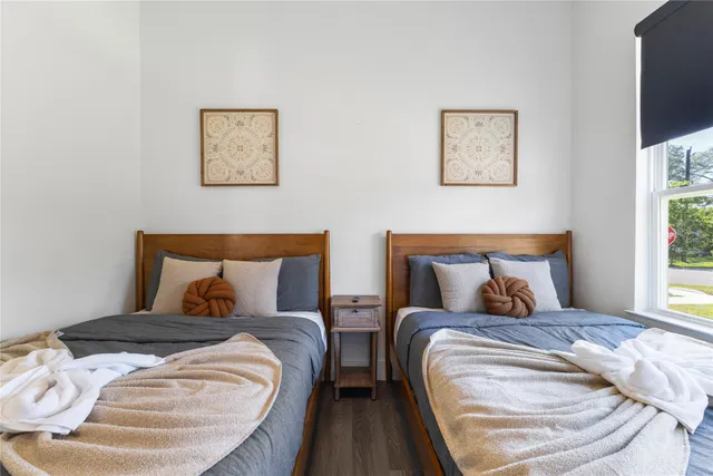 a bed sitting in a bedroom and next to a window