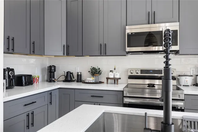 a kitchen with stainless steel appliances granite countertop a sink and a microwave