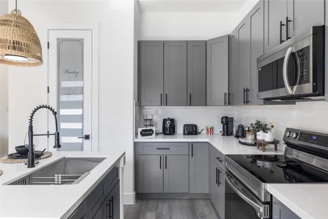 a kitchen with stainless steel appliances granite countertop a sink stove and cabinets