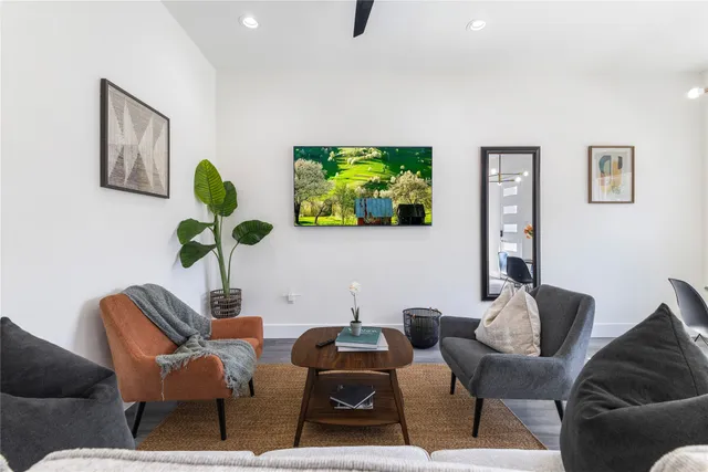 a living room with furniture a window and a flat screen tv