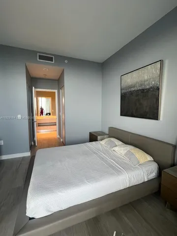 a bedroom with a bed and a painting on the wall
