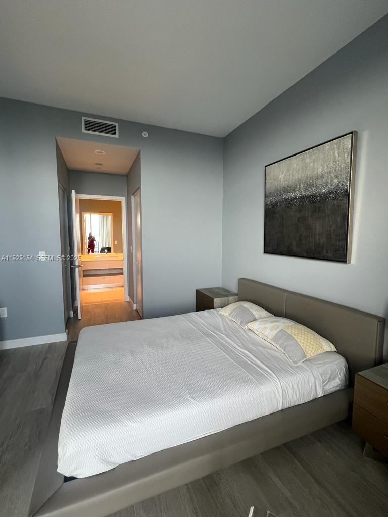 55 Southwest 9th Street, Unit 4205 Miami, FL 33130 - Photo 19 of 37 a bedroom with a bed and a painting on the wall