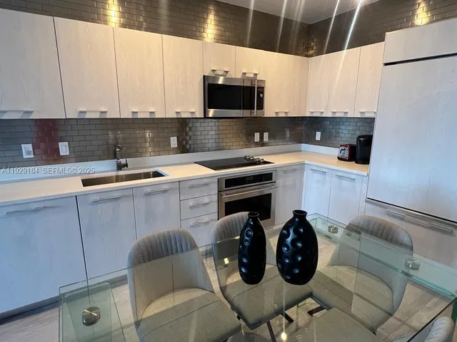 a kitchen with a sink cabinets and stainless steel appliances