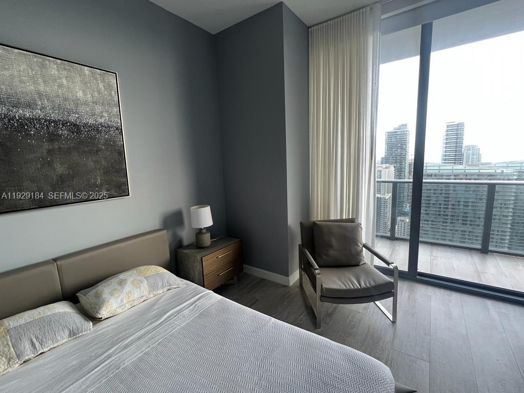 55 Southwest 9th Street, Unit 4205 Miami, FL 33130 - Photo 28 of 37 a bedroom with a bed and wooden floor