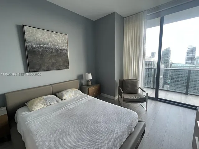 a bedroom with a bed and glass window