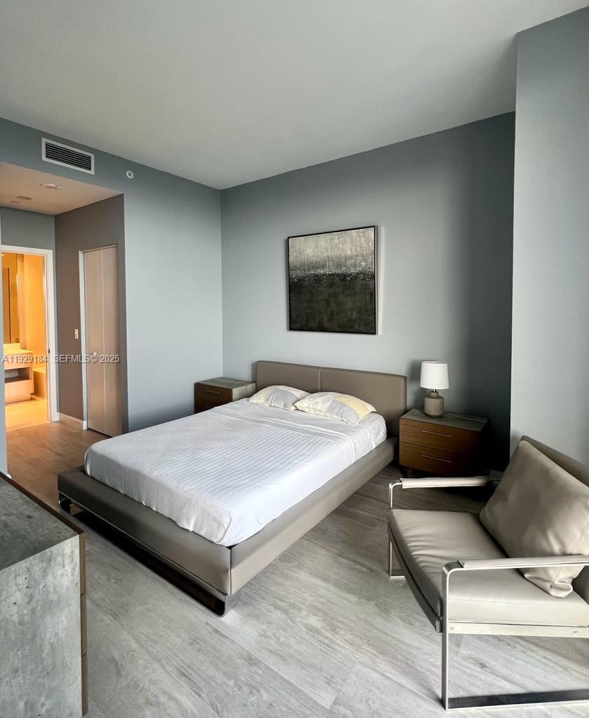 55 Southwest 9th Street, Unit 4205 Miami, FL 33130 - Photo 35 of 37 a bedroom with a bed and chair