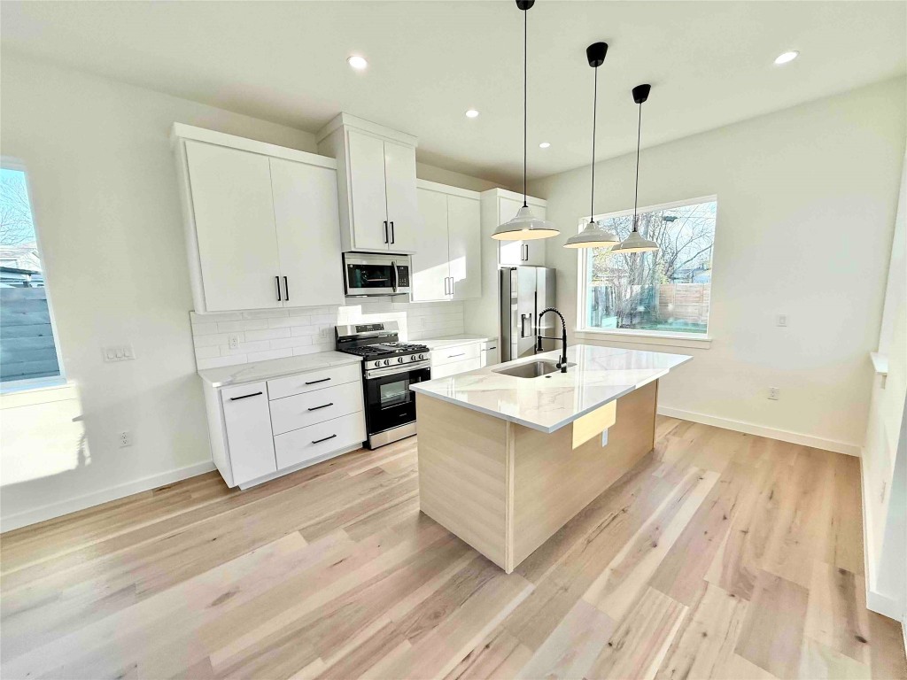 6809 Porter Street, Unit 2 Austin, TX 78741 - Photo 4 of 12 a large white kitchen with stainless steel appliances