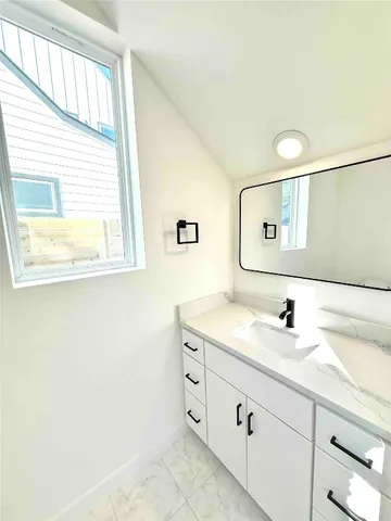 a bathroom with a granite countertop sink a mirror and a window