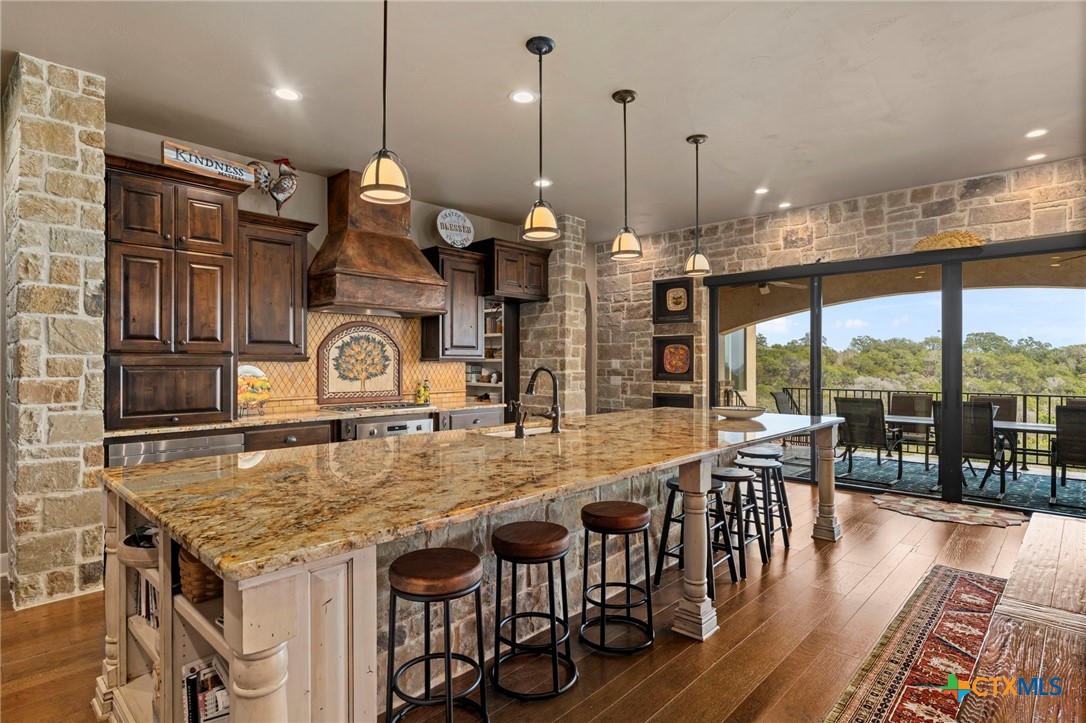 1039 Bluewater Place Spring Branch, TX 78070 - Photo 17 of 48 a kitchen with stainless steel appliances granite countertop a stove top oven a dining table and chairs