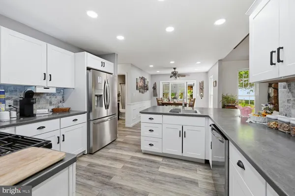 a kitchen with white cabinets and stainless steel appliances