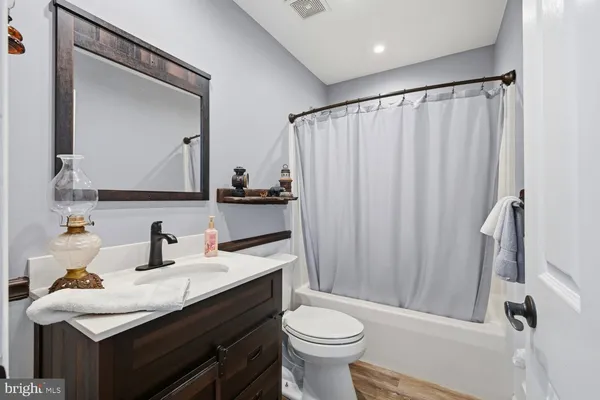 a bathroom with a sink a toilet and shower curtain